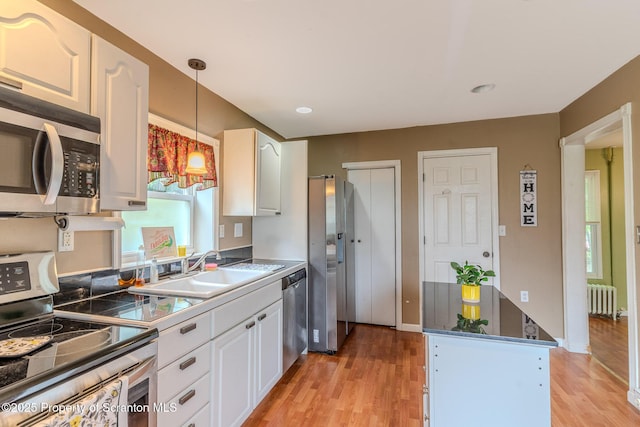 51 Plank St, Pittston, PA 18640 - kitchen with stainless steel appliances, radiator, white cabinets, light wood-style floors, and recessed lighting