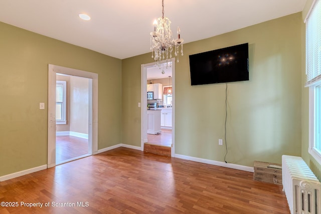 51 Plank St, Pittston, PA 18640 - unfurnished dining area with radiator, a chandelier, and wood finished floors