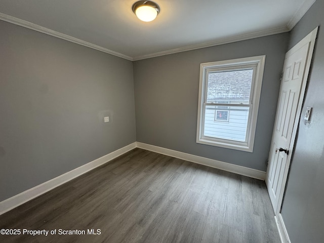 empty room featuring crown molding and dark hardwood / wood-style floors