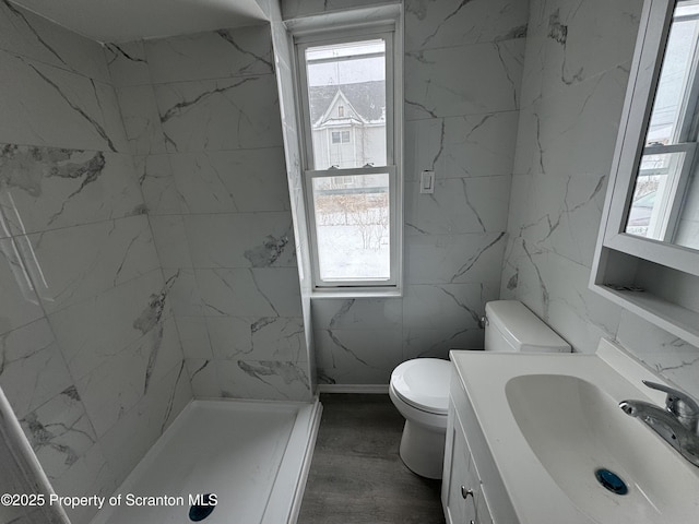 bathroom featuring a shower, hardwood / wood-style floors, vanity, and toilet