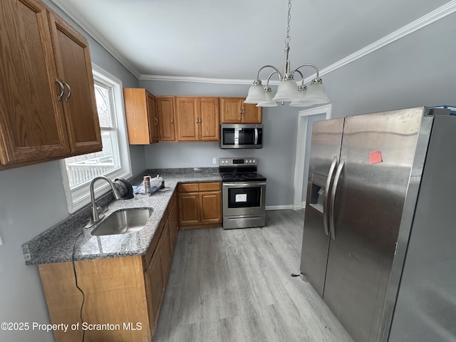 kitchen with sink, hanging light fixtures, stainless steel appliances, a notable chandelier, and dark stone counters