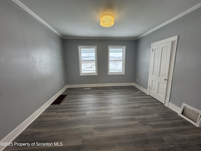 unfurnished room featuring baseboards, visible vents, dark wood-type flooring, and crown molding