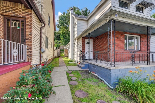 446 10th Ave, Scranton, PA 18504 - view of home's exterior featuring covered porch, a chimney, and brick siding