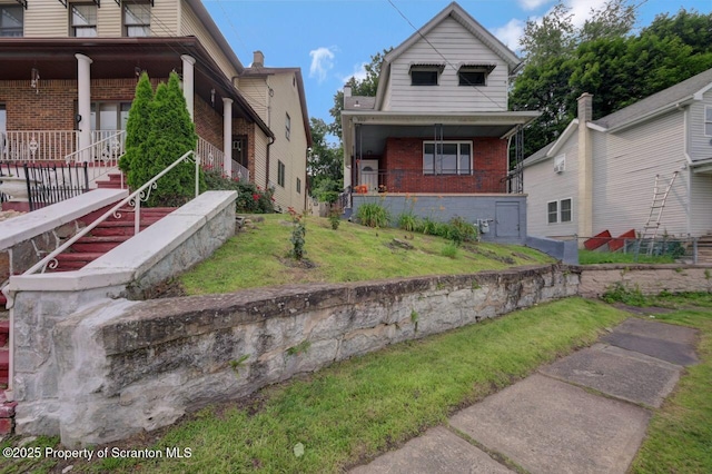 446 10th Ave, Scranton, PA 18504 - view of front of house featuring brick siding, a front yard, and a porch