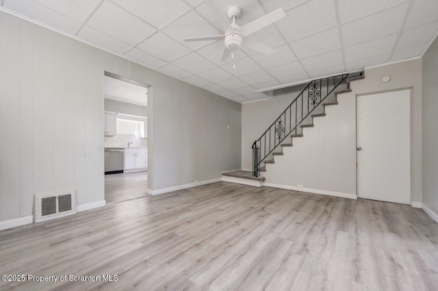 446 10th Ave, Scranton, PA 18504 - unfurnished living room featuring wood finished floors, a ceiling fan, stairs, and a paneled ceiling