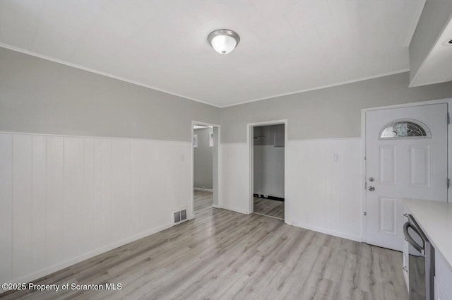 446 10th Ave, Scranton, PA 18504 - unfurnished living room with light wood finished floors, a wainscoted wall, and crown molding