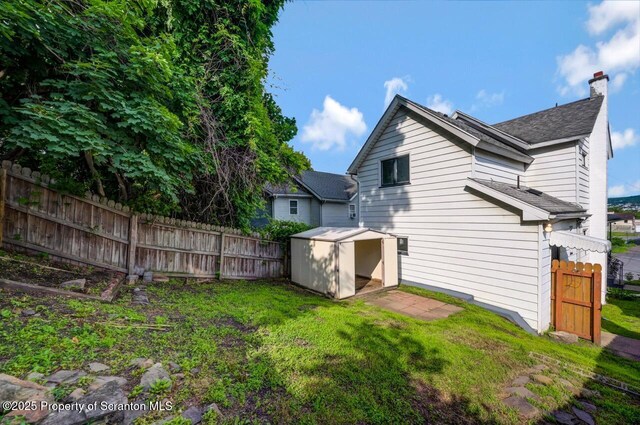 446 10th Ave, Scranton, PA 18504 - back of property with a storage shed, a shingled roof, and a chimney