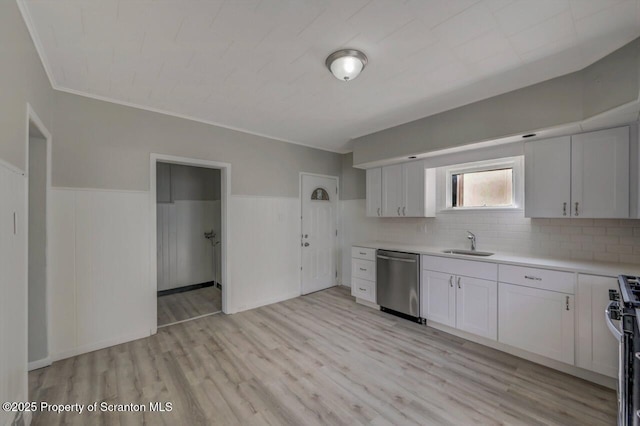 446 10th Ave, Scranton, PA 18504 - kitchen with appliances with stainless steel finishes, light countertops, wainscoting, white cabinets, and light wood-type flooring