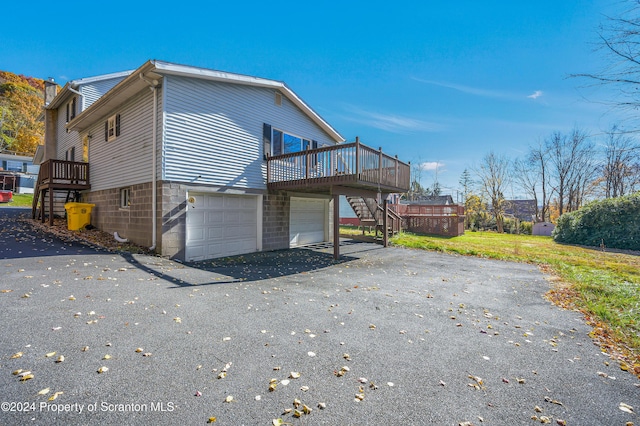 view of property exterior with a wooden deck and a garage