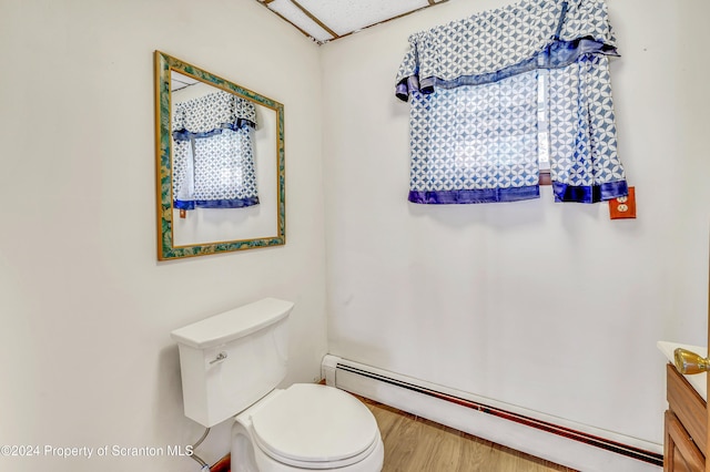 bathroom with vanity, hardwood / wood-style flooring, toilet, and baseboard heating