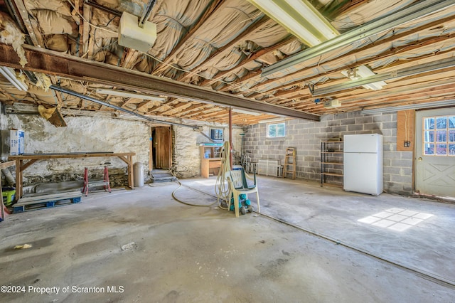 basement with white refrigerator