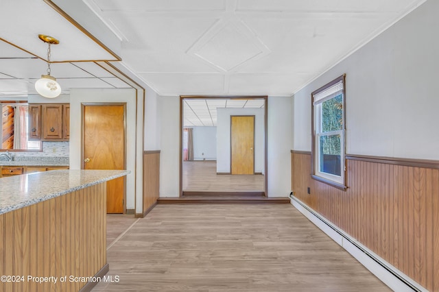 hallway featuring baseboard heating, crown molding, and light wood-type flooring