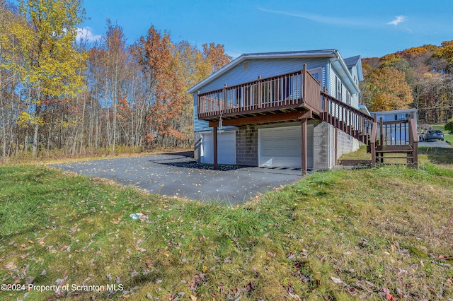 view of home's exterior with a garage and a deck