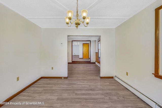 unfurnished dining area featuring hardwood / wood-style flooring, baseboard heating, and an inviting chandelier