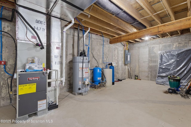 basement featuring electric panel and water heater