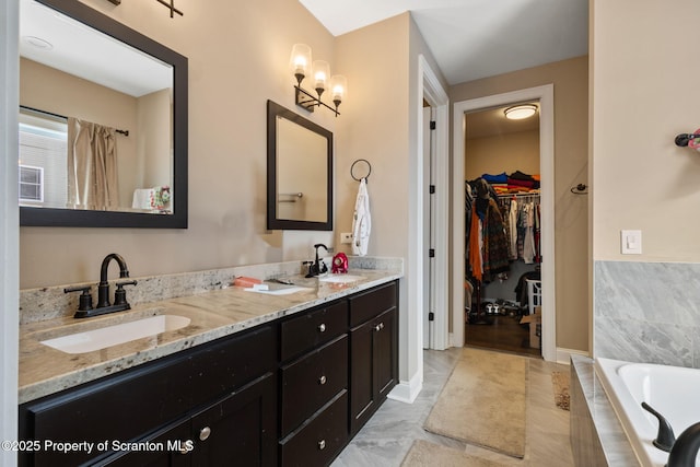 bathroom featuring vanity, a notable chandelier, and tiled tub