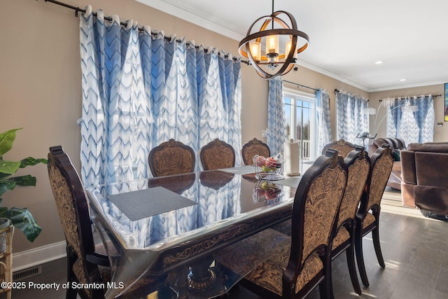 dining area with ornamental molding, dark hardwood / wood-style floors, and an inviting chandelier