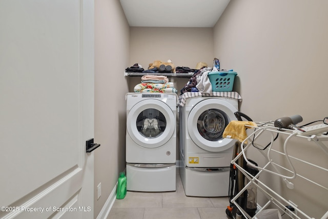 clothes washing area with light tile patterned floors and washing machine and clothes dryer