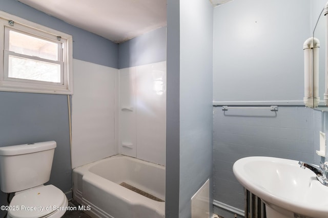 full bathroom featuring a sink, a wainscoted wall, and toilet