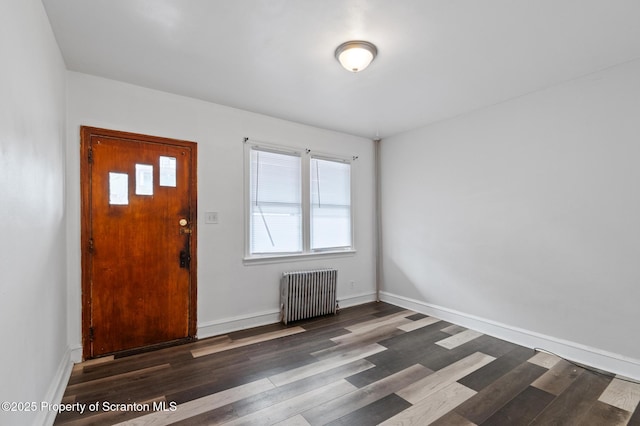entrance foyer featuring baseboards, wood finished floors, and radiator