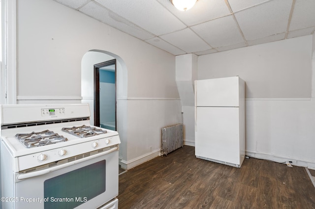 kitchen featuring a paneled ceiling, arched walkways, radiator, white appliances, and dark wood-type flooring