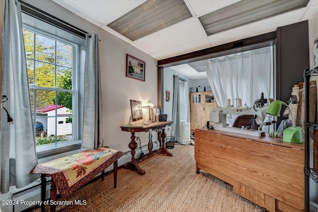 interior space featuring a drop ceiling and baseboard heating