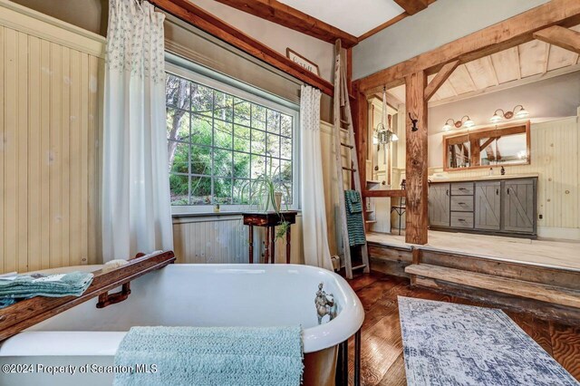 sitting room featuring a jacuzzi, beam ceiling, dark hardwood / wood-style flooring, and wood walls