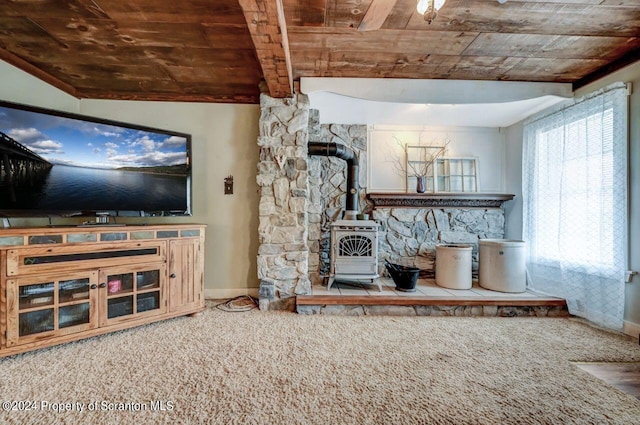 unfurnished living room with lofted ceiling with beams, a wood stove, carpet floors, and wooden ceiling