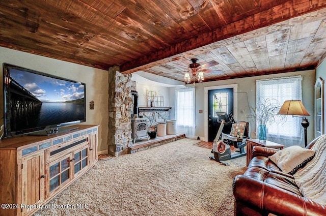 carpeted living room with beamed ceiling, a wood stove, ceiling fan, and wood ceiling