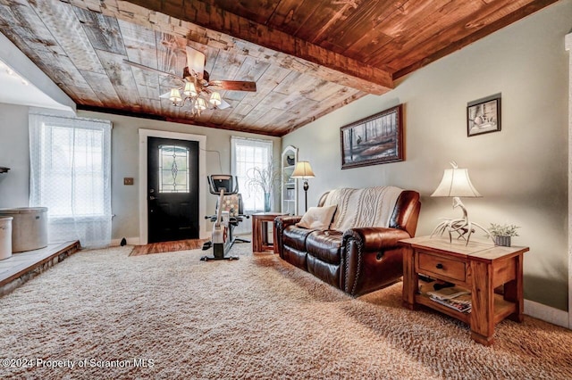 living room with ceiling fan, beamed ceiling, carpet floors, and wood ceiling