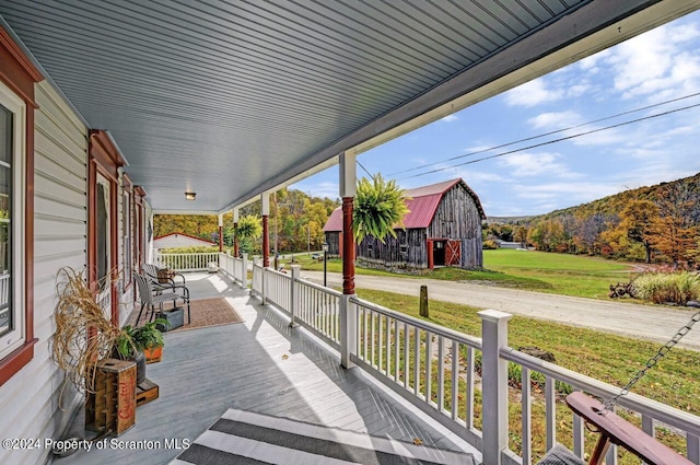 deck with a mountain view, a porch, and an outdoor structure