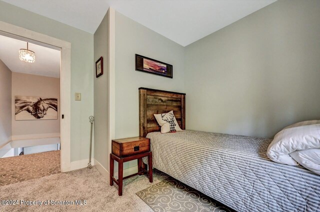 bedroom with a notable chandelier and light colored carpet