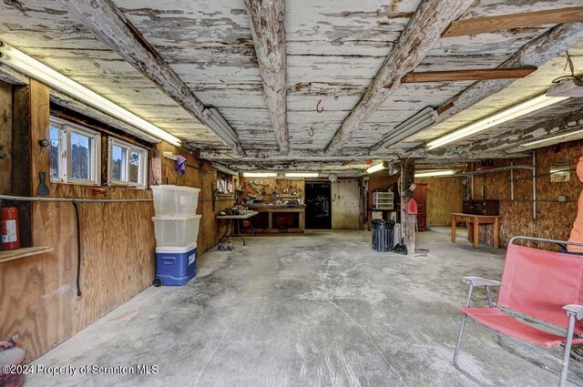 basement featuring a workshop area and wooden walls