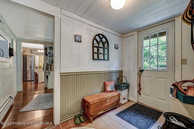 doorway with tile patterned flooring, a baseboard radiator, and wooden ceiling