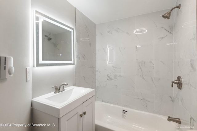 bathroom with tiled shower / bath combo and vanity