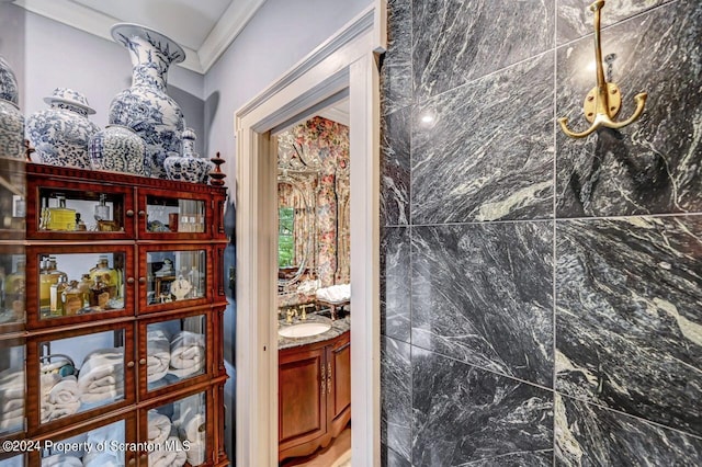 bathroom with vanity, crown molding, and tile walls