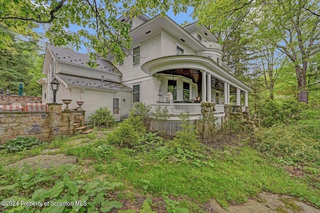 rear view of house featuring a porch