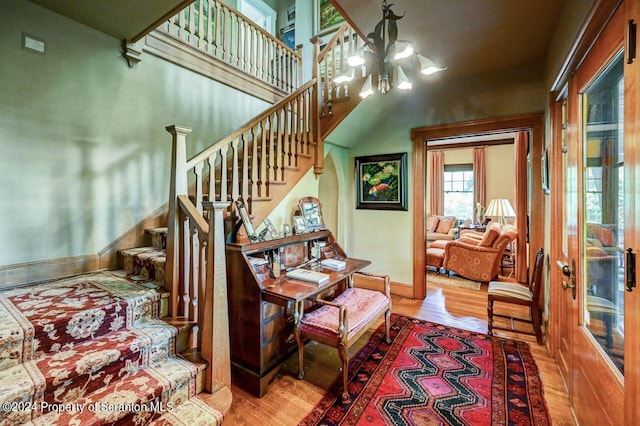 staircase with a notable chandelier and wood-type flooring