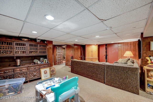 interior space with a paneled ceiling and wood walls