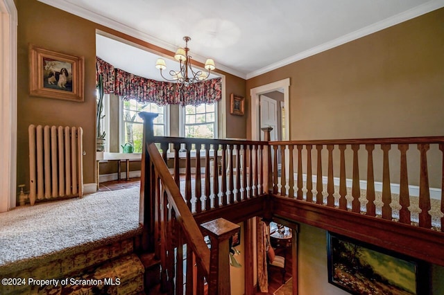 stairs with radiator heating unit, carpet floors, ornamental molding, and a notable chandelier