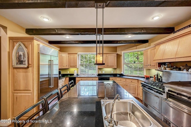 kitchen with beam ceiling, light brown cabinetry, a healthy amount of sunlight, and decorative light fixtures