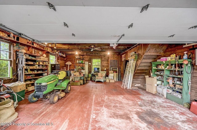 garage with ceiling fan and wood walls