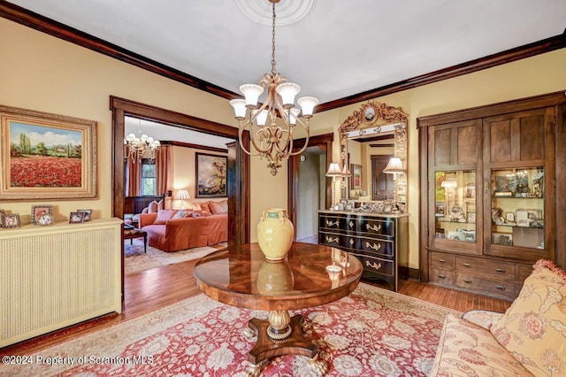 interior space with crown molding, light hardwood / wood-style floors, and an inviting chandelier