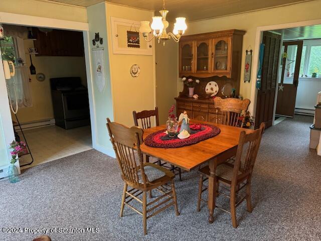 carpeted dining area with a baseboard radiator and a chandelier