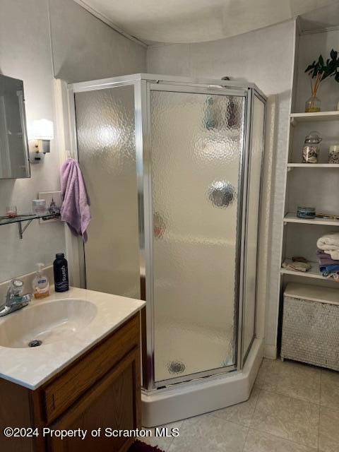 bathroom with tile patterned floors, vanity, and an enclosed shower