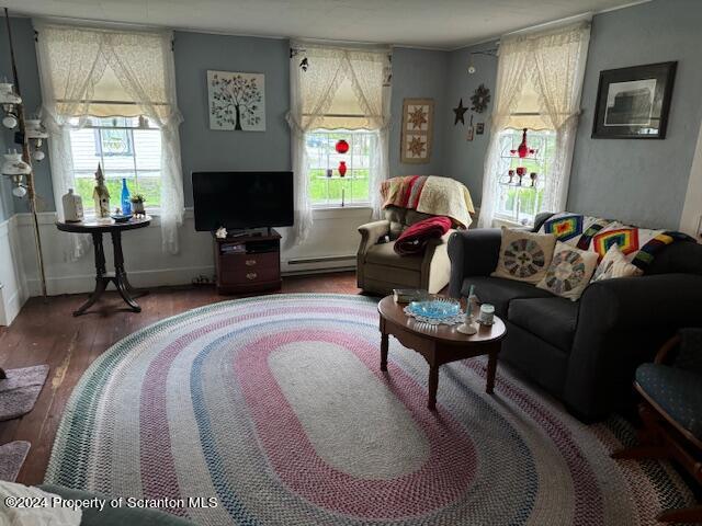 living room with hardwood / wood-style flooring and a baseboard heating unit