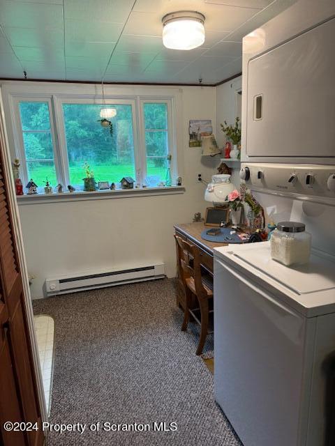 bathroom with stacked washer and dryer and a baseboard heating unit