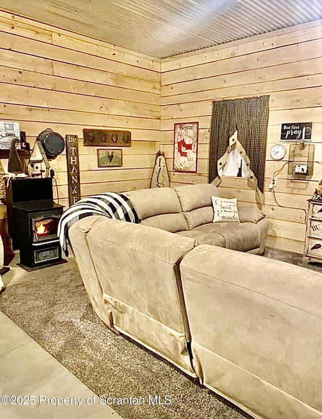 living area featuring wood walls and a wood stove