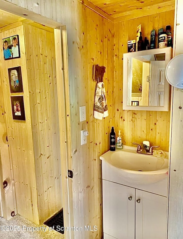 bathroom featuring wood walls and vanity