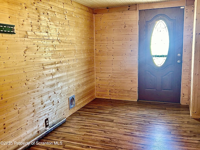 foyer with dark wood-type flooring and wood walls